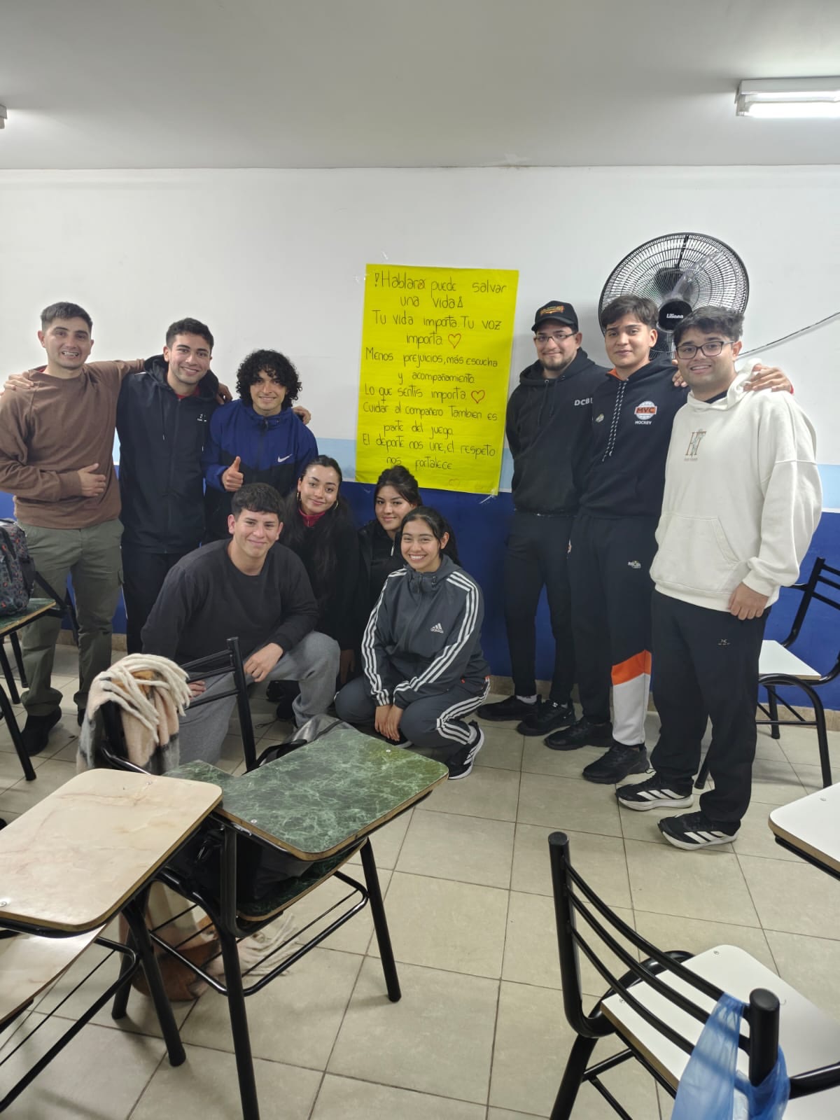 Estudiantes del Profesorado de Educación Física junto a un mensaje de concientización